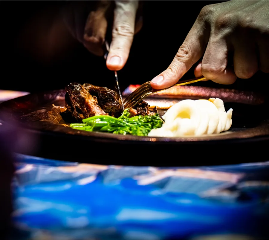 A person cutting food on a plate